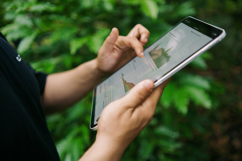 Uma pessoa segurando um tablet digital ao ar livre