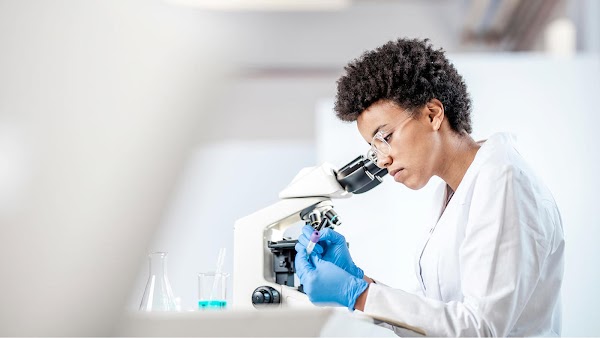 Researcher looking through a microscope
