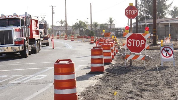 truck driving by orange barrels in construction zone