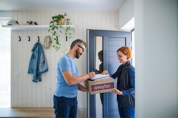 A man signing his delivery for the Wayfair package
