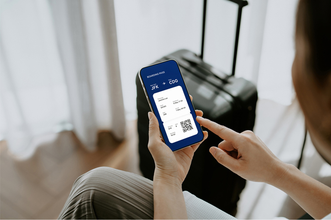 A woman holding a smartphone with her boarding pass open on it