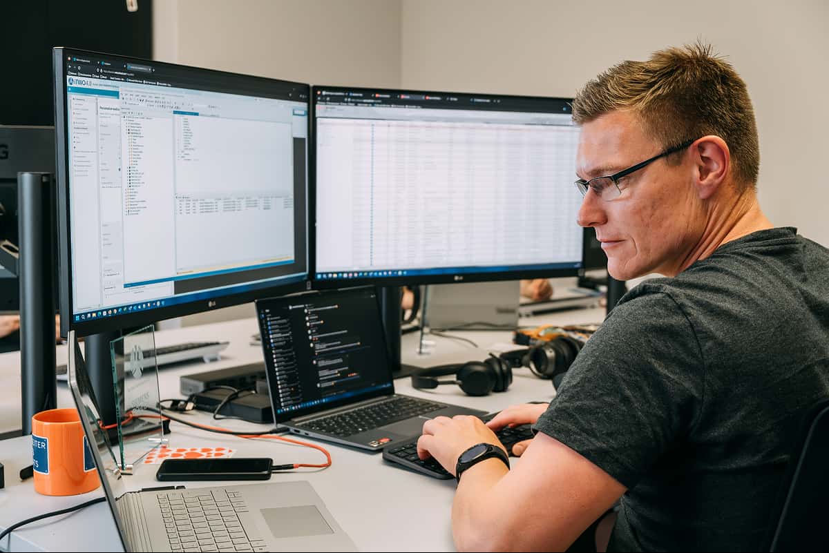 Man viewing dual computer screens
