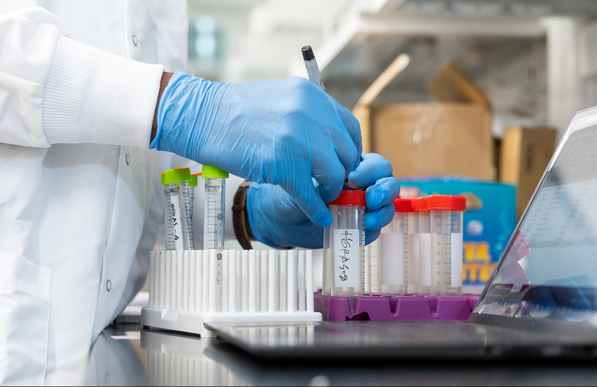 Close-up view of a person, likely a scientist or lab technician, working in a laboratory setting