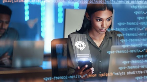 woman using phone and laptop with code visualization