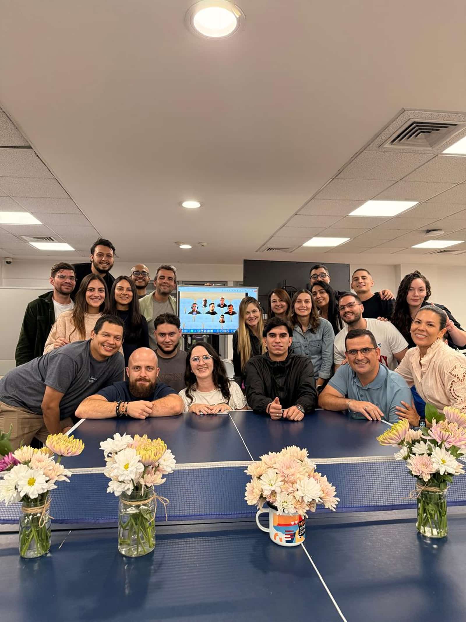 Foto grupal del equipo en la oficina con flores