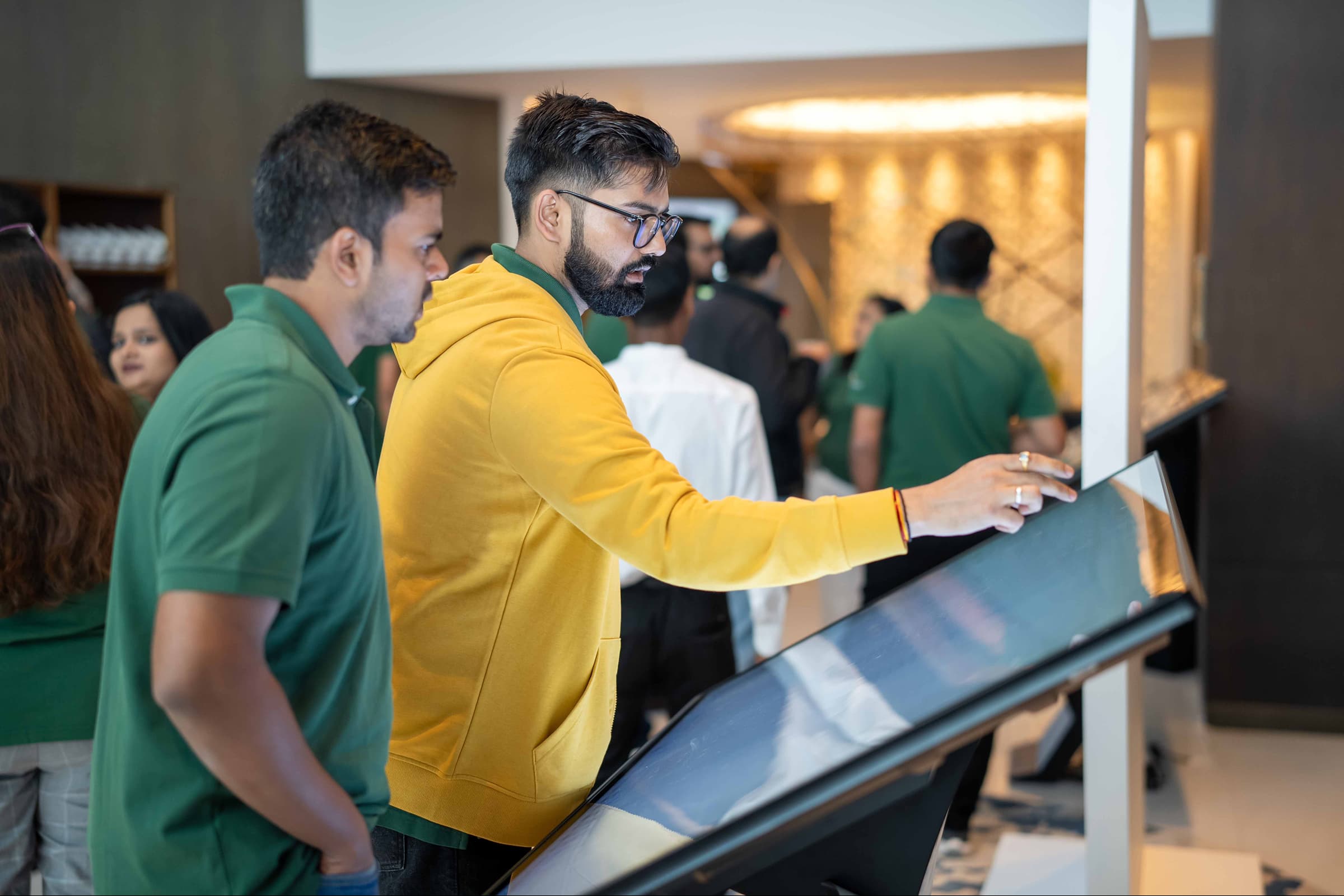Man in yellow hoodie demoing a software touch interface