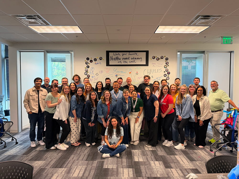 Office group photo with handwritten wall notes