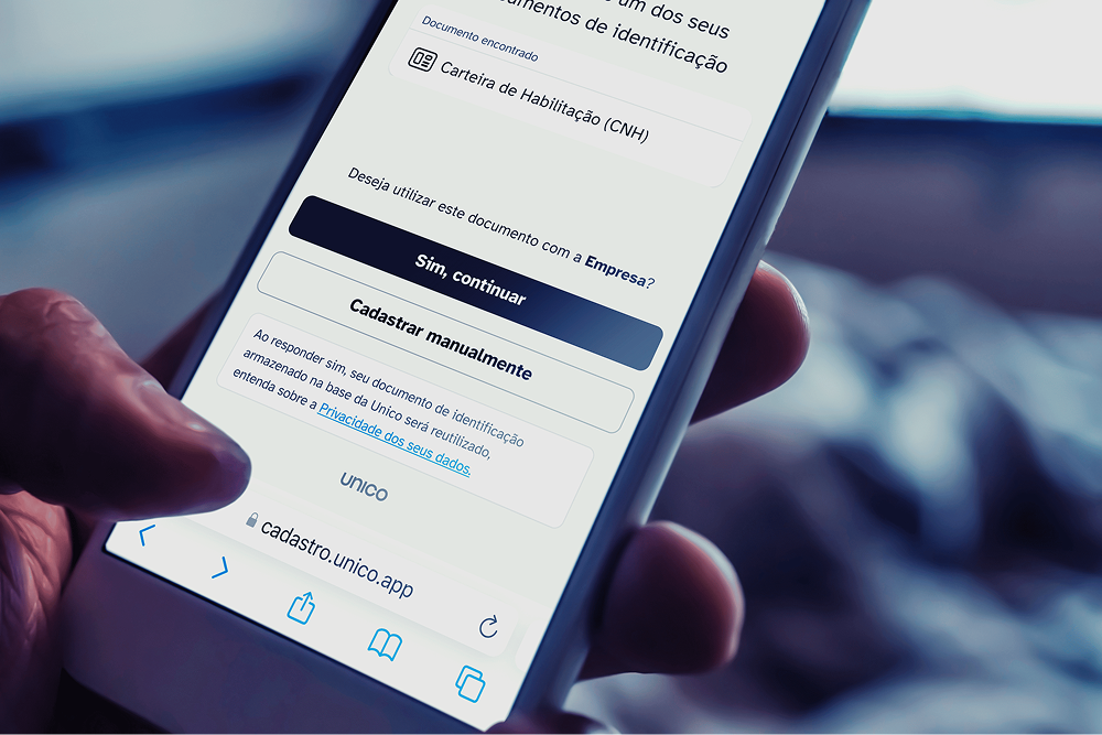 A person holding a smartphone displaying a Portuguese verification page from Unico to reuse a driver's license