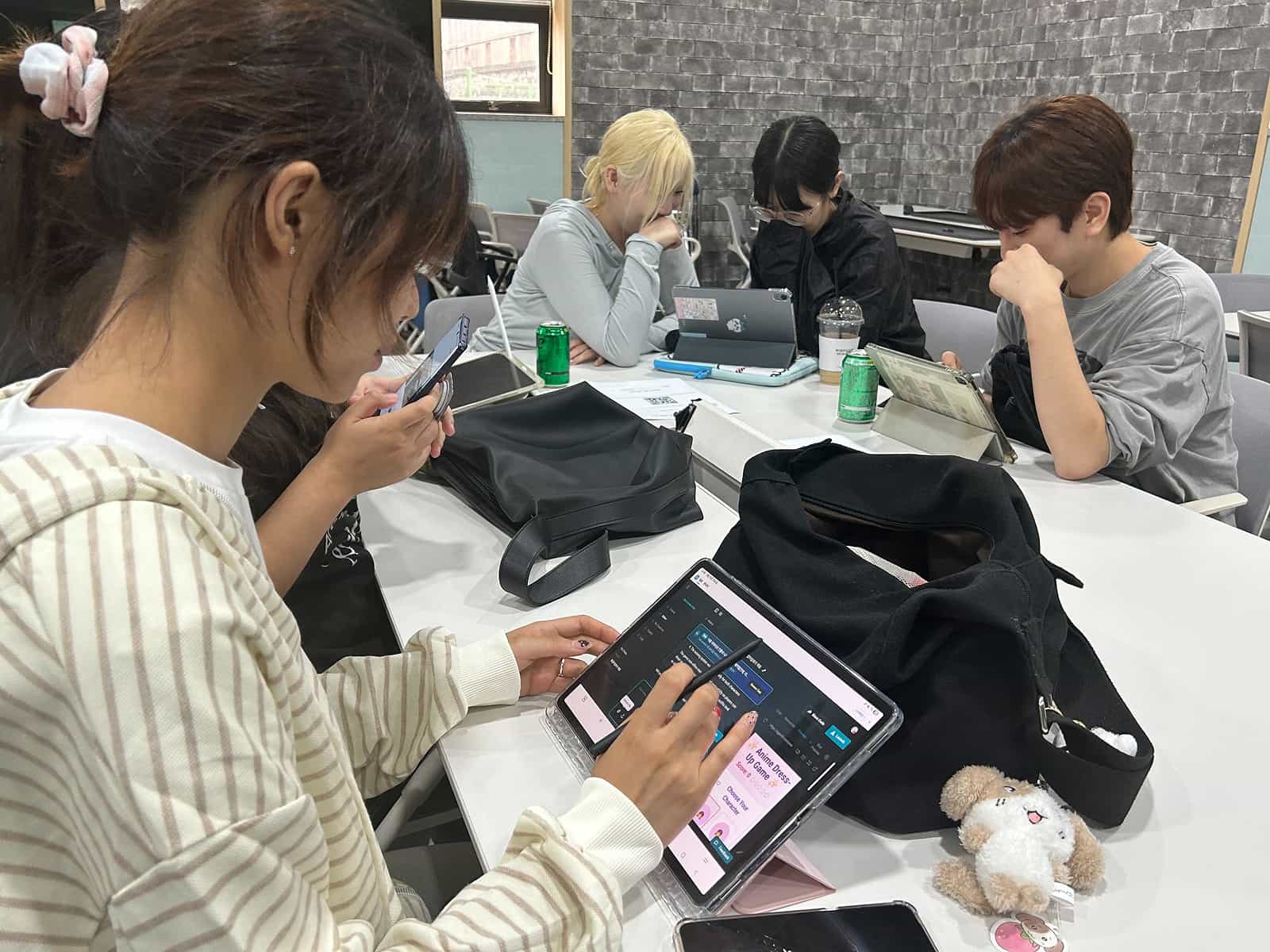 Students using tablets and phones at a table