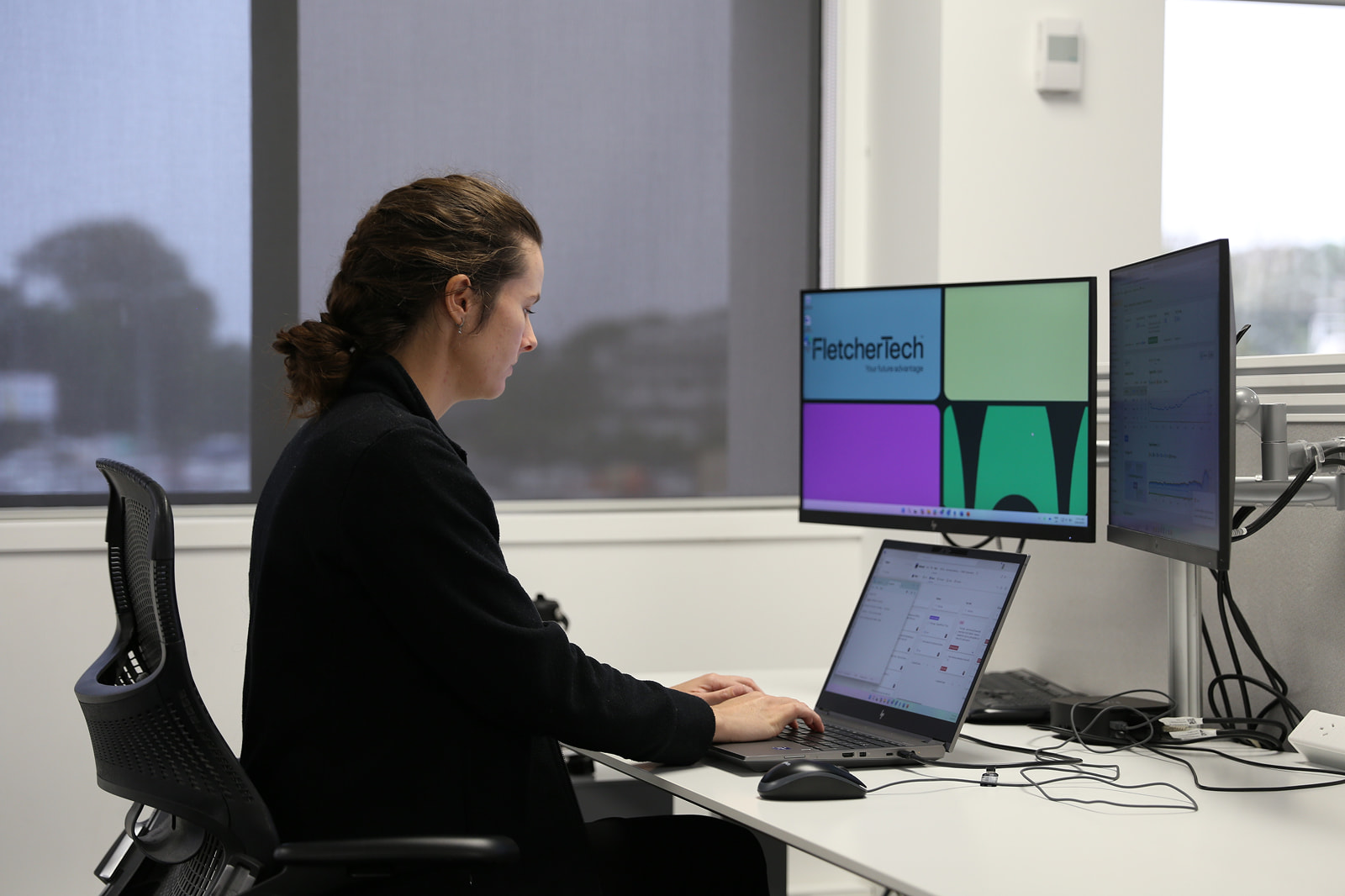 Lady viewing desktop and laptop screen