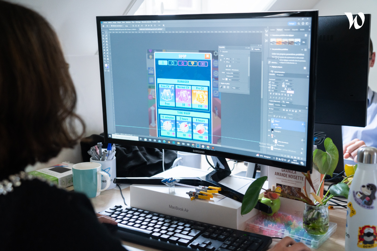 A person working at a desk setup with a widescreen curved computer monitor and a keyboard