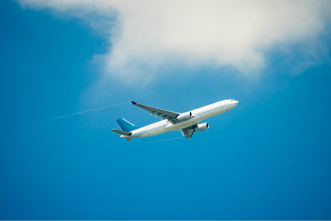 A white airplane flying in the sky
