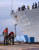 Navy personnel working from dock and on the ship
