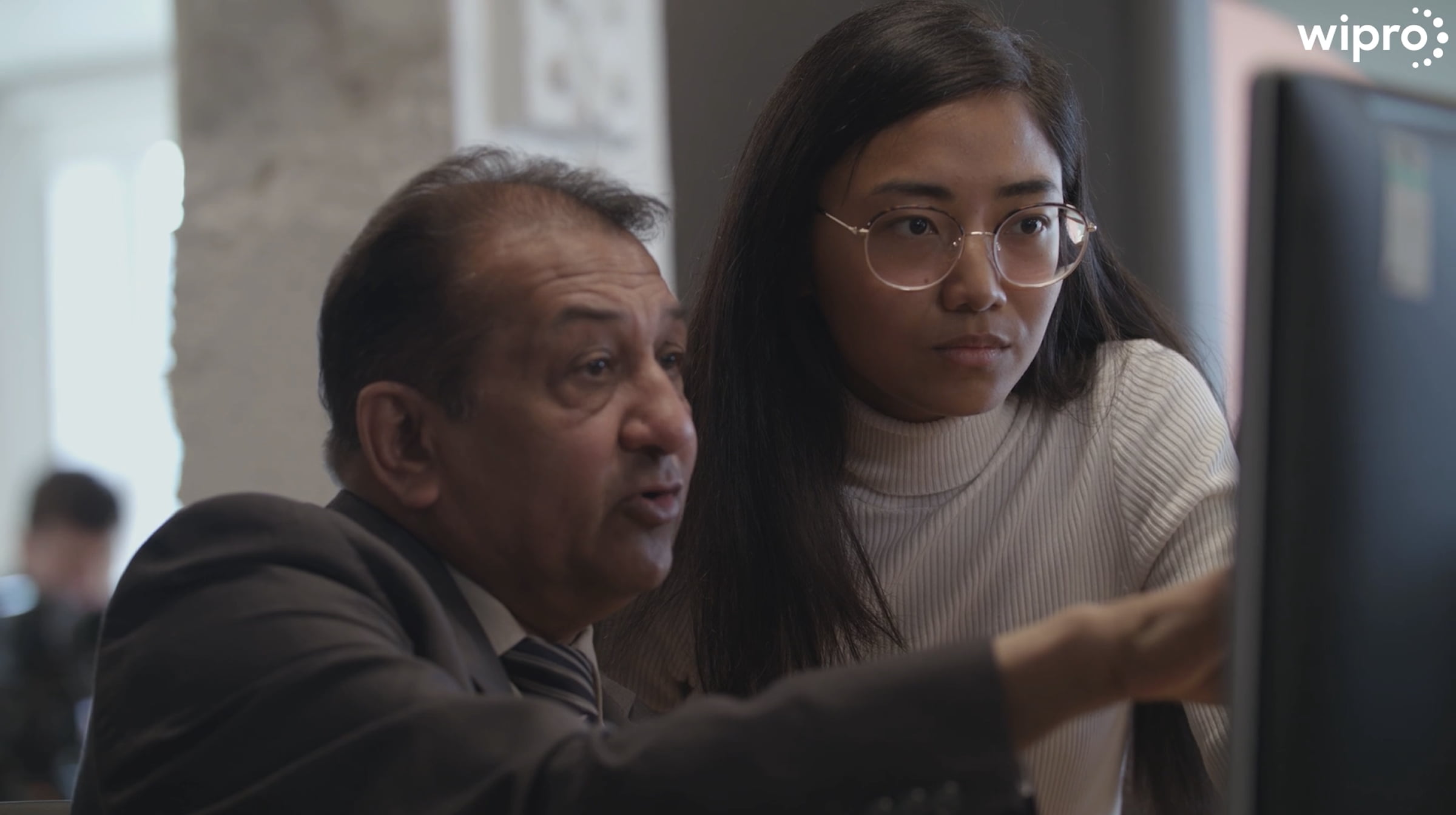 A man and woman in front of a computer