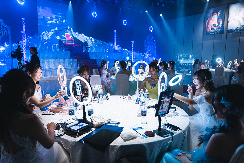 身著禮服的主播們在17LIVE活動桌旁直播