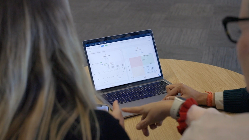 Three people looking at a laptop screen