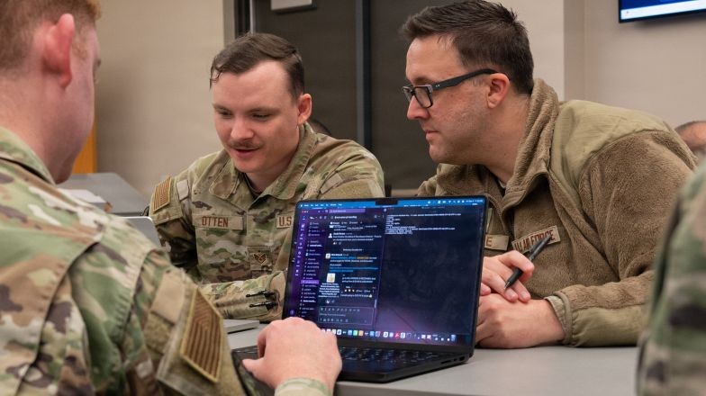 People working on code across multiple laptops