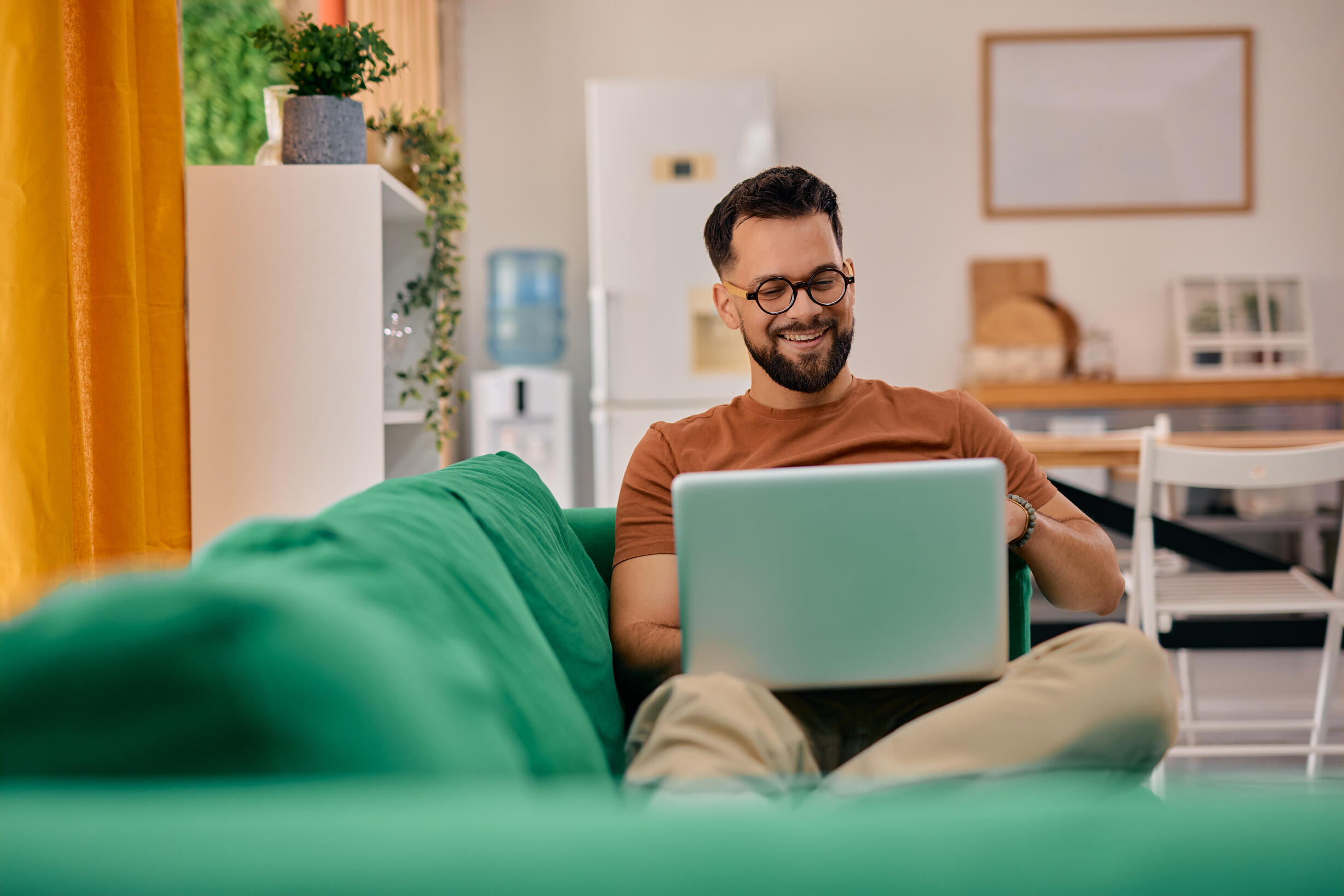 Man on green couch with laptop
