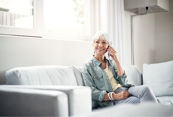 Lady sitting on the couch and listening on the mobile