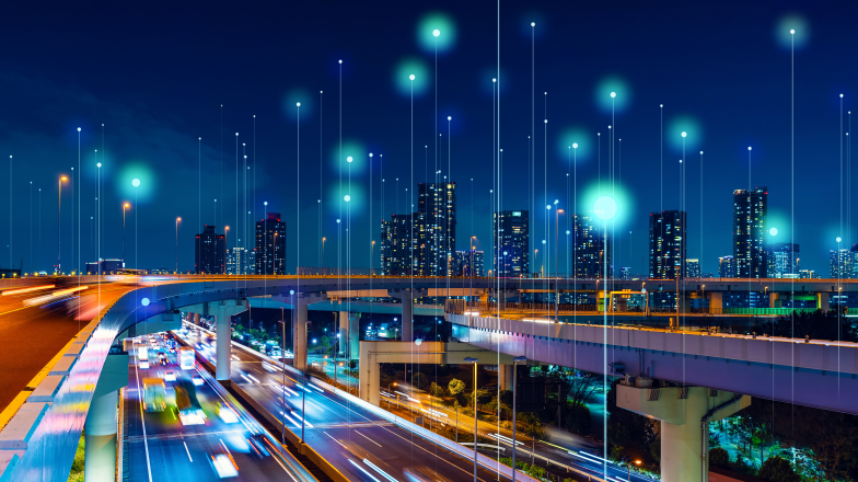 highway system in front of a city with pinpoints of light