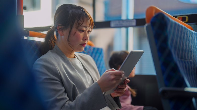 woman viewing device on public transportation