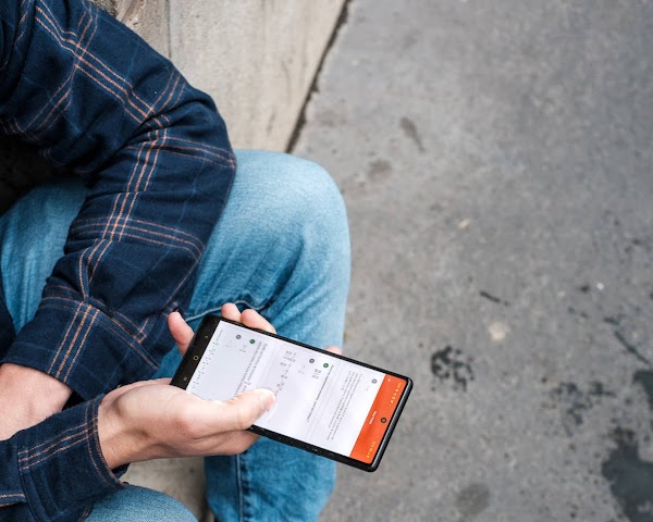 A person checking Nomad Education app on a smartphone