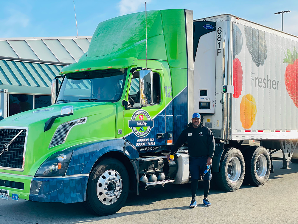 A man standing near a green truck