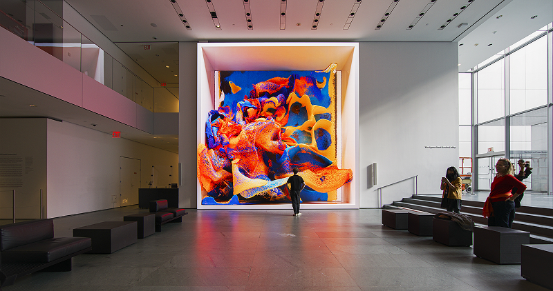 Swirling digital art installation in a white museum lobby
