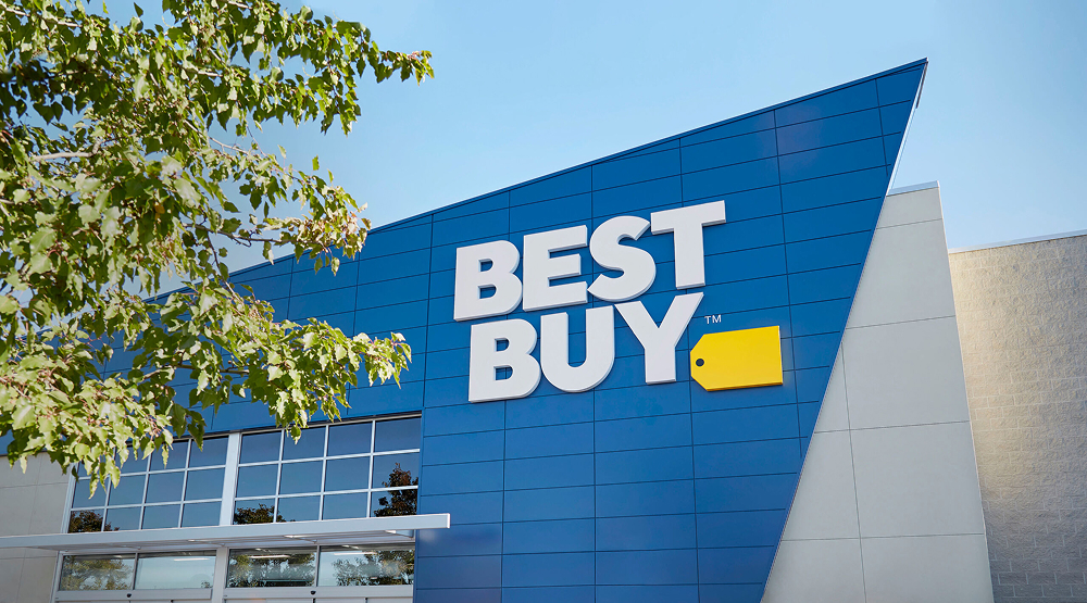 Exterior view of a Best Buy store with its blue and yellow sign under a clear sky