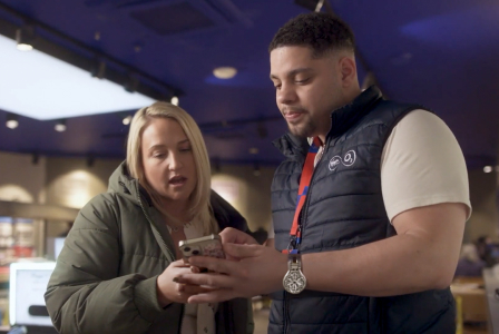 Man showing a cell phone to a woman