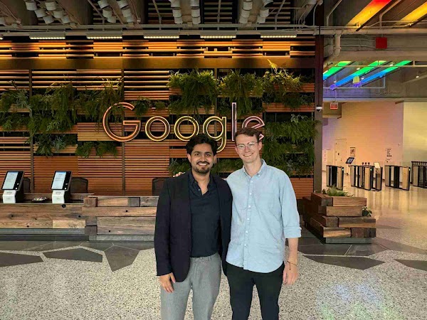 Two individuals with Google logo in the background