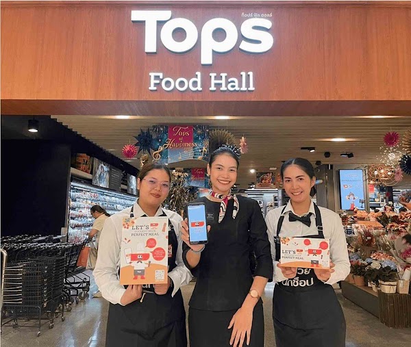 Three women promoting Tops grocery with brochures and mobile app