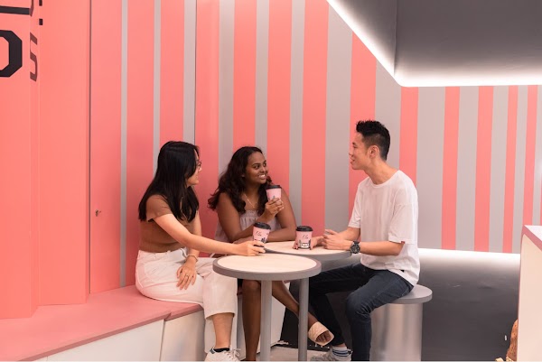 Two women and a man enjoying coffee