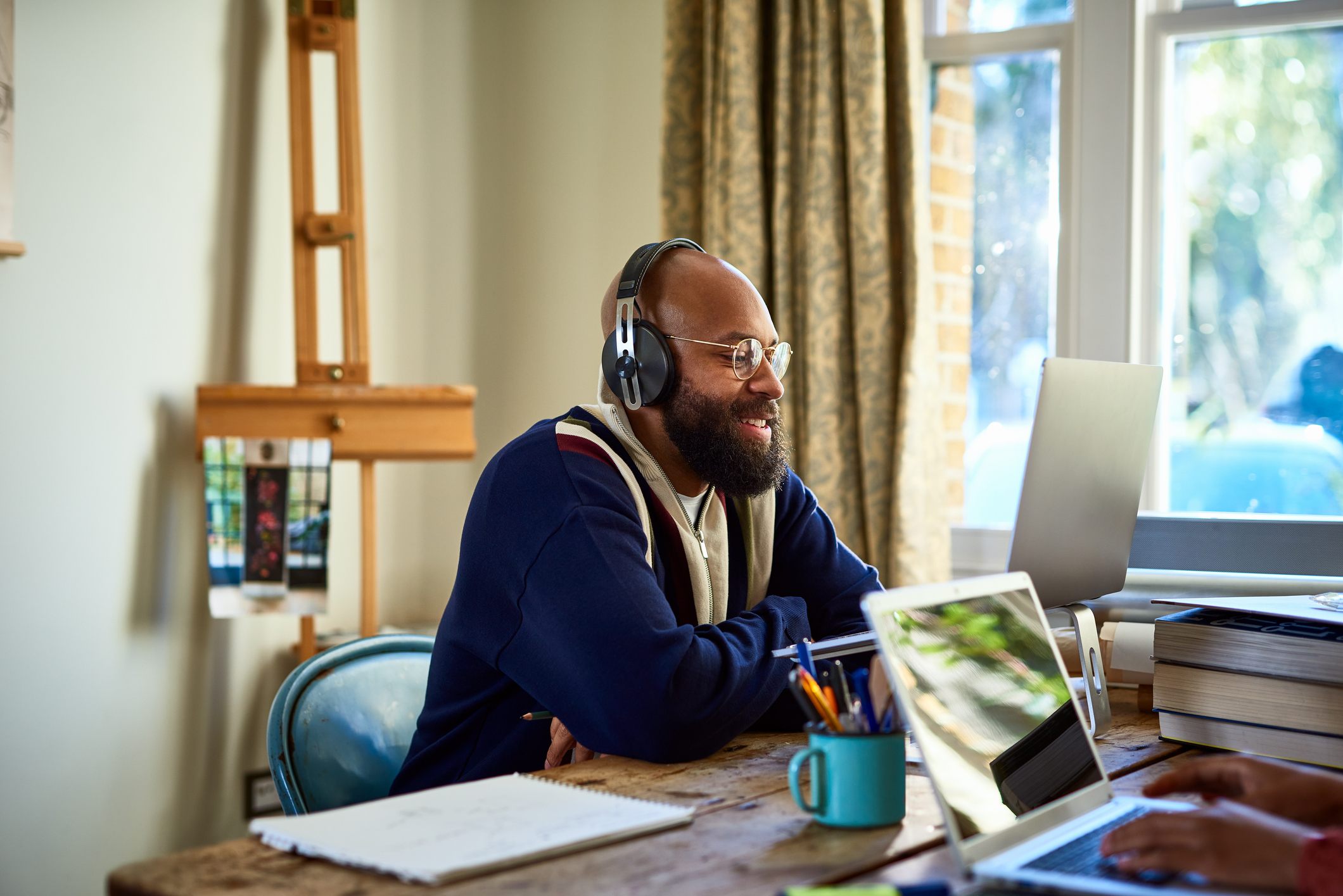 Man with headphones sitting at wooden desk