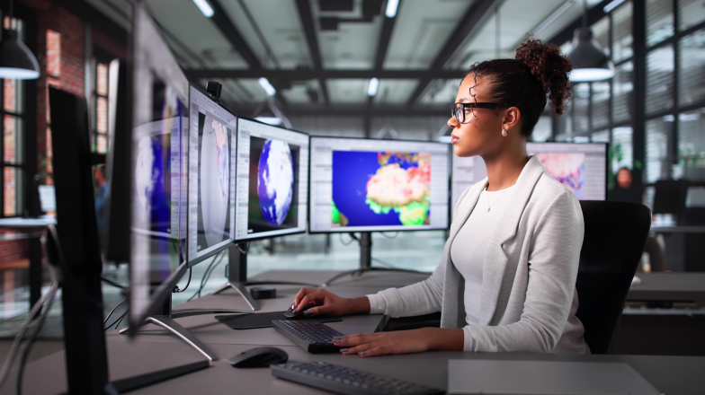 woman monitoring multiple screens with global views and weather forecasts