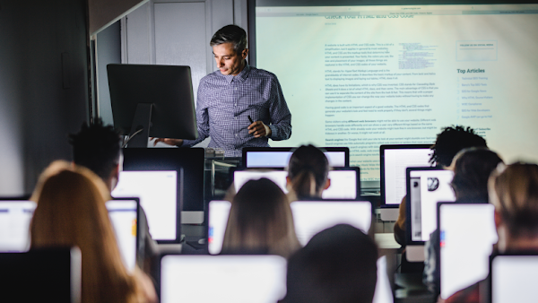 professor leading class with students using computers