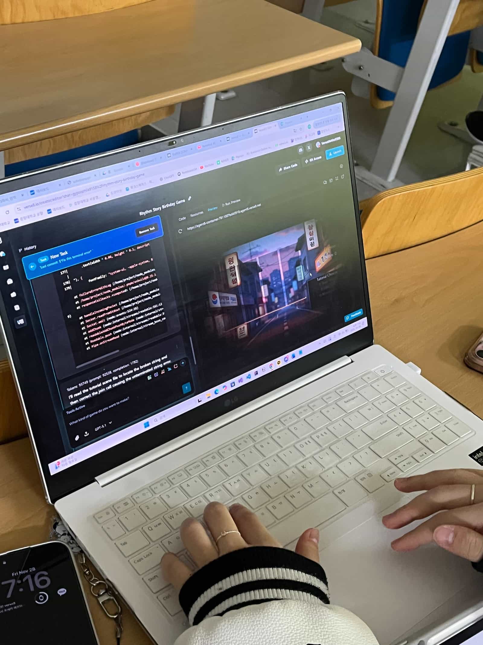 Person coding a rhythm game on a laptop in a classroom
