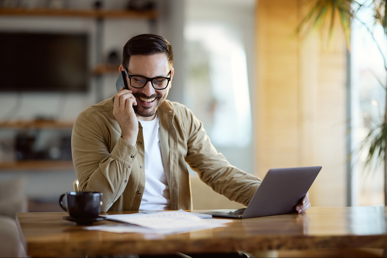 Hombre con una computadora portátil hablando por teléfono móvil