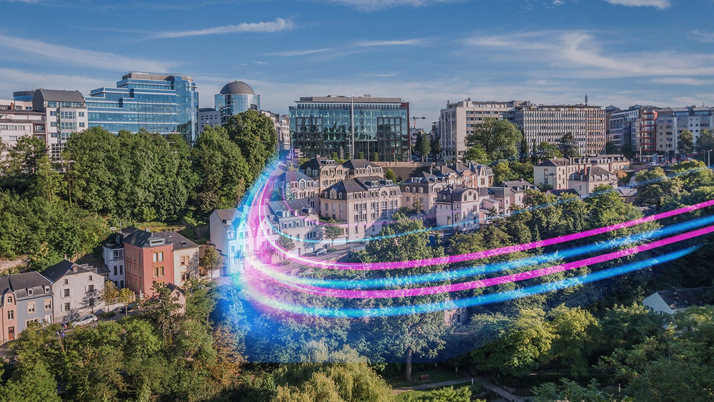 An aerial view of a European city features green trees, residential houses, and abstract blue and pink light streams