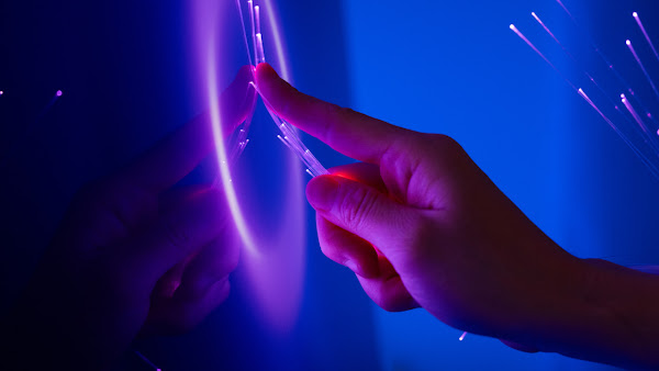 main touchant des fibres optiques