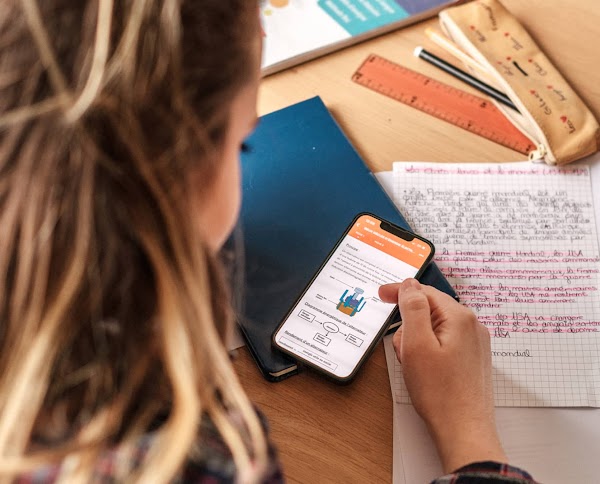 A girl scrolling through Nomad Education app on a smartphone