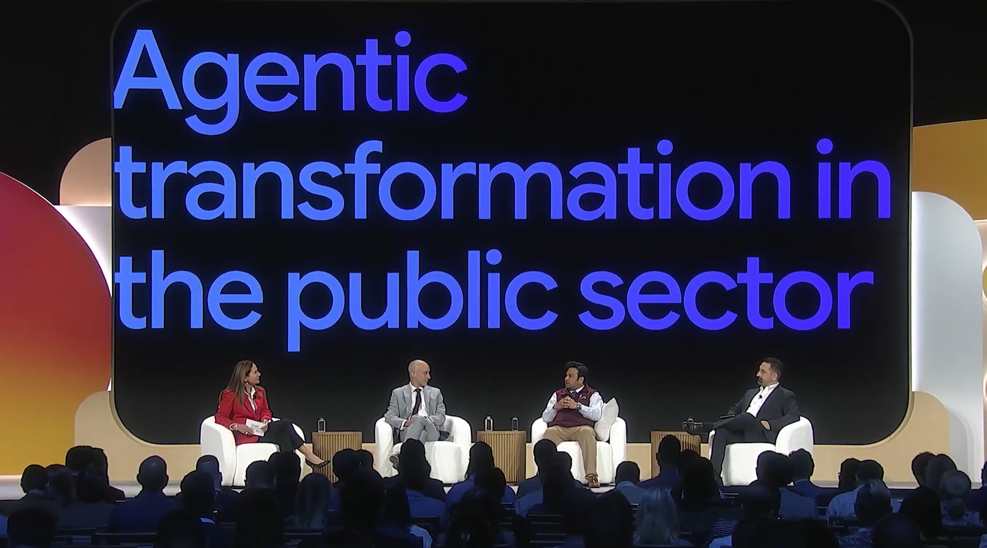 conference with four speakers on stage with Agentic Transformation in the public sector in the background