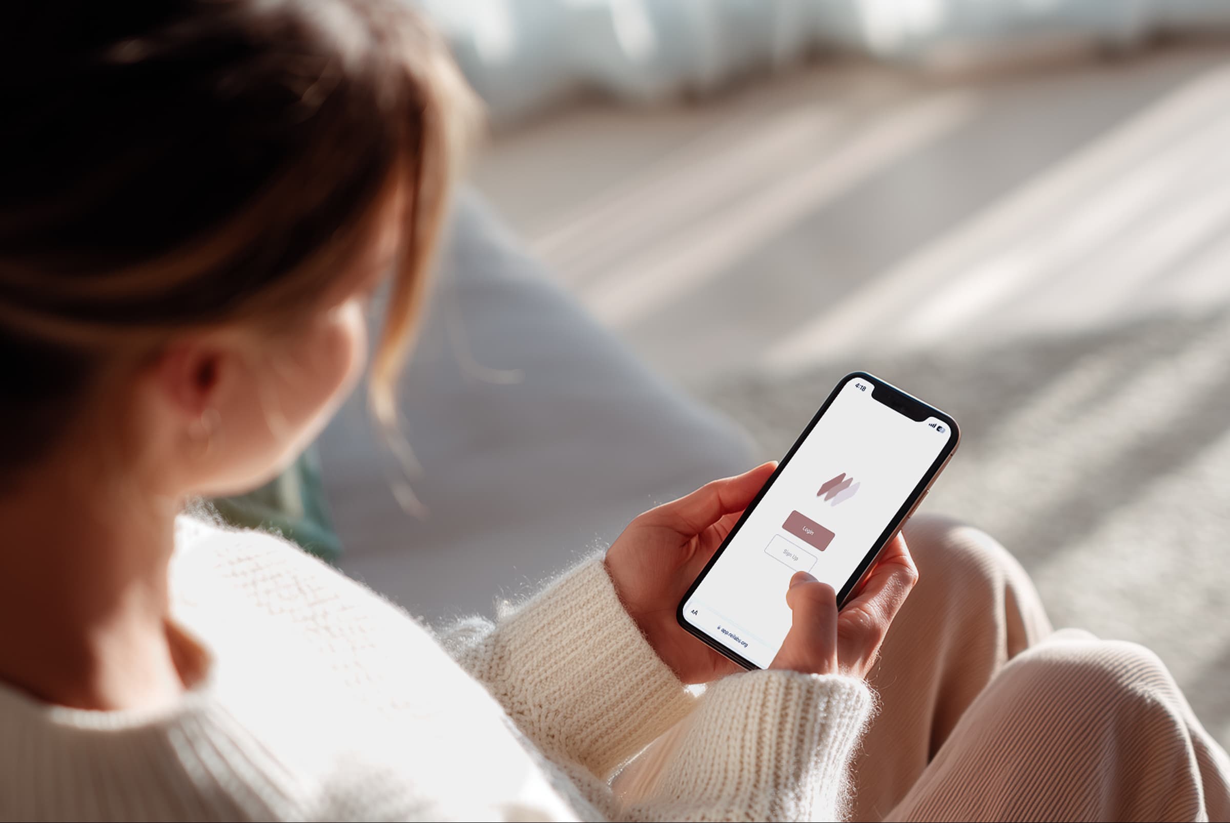 A woman holding an iPhone with Rei Labs app open on it