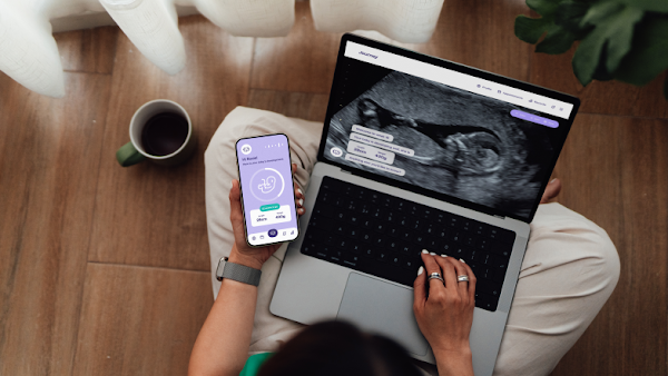 woman using phone and laptop to review maternal health biometrics