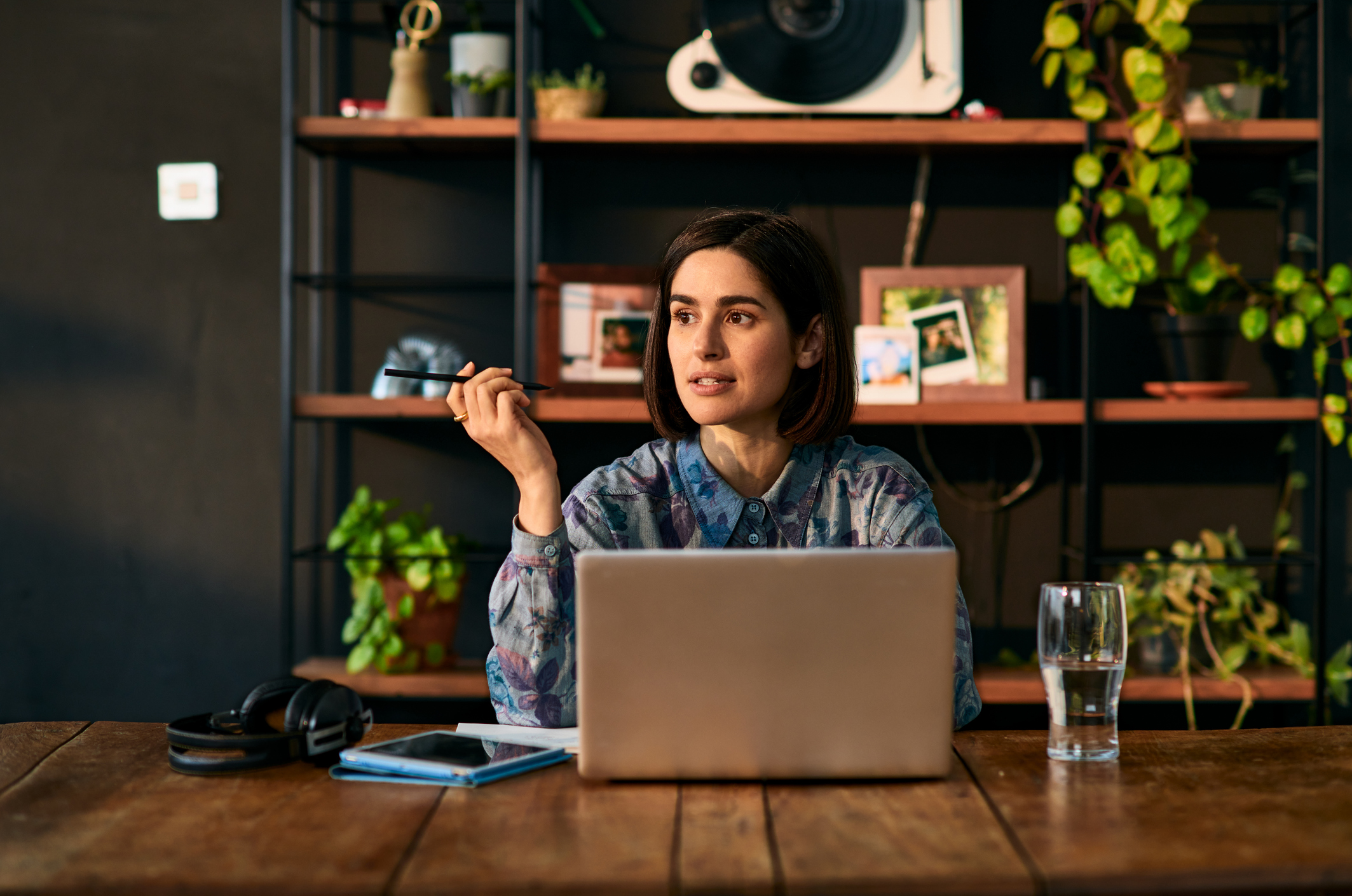 Women sitting at wooden table next to an open laptop
