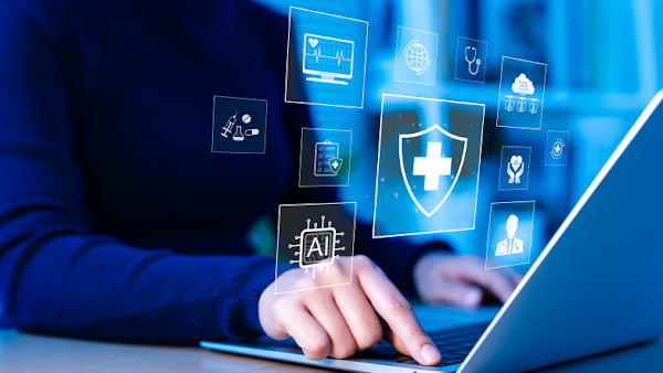 person working at laptop with holographic logos about AI and healthcare