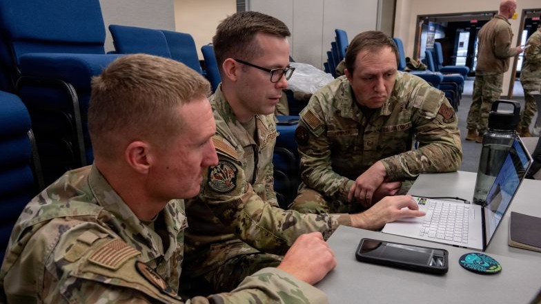 Military personnel review information on their devices