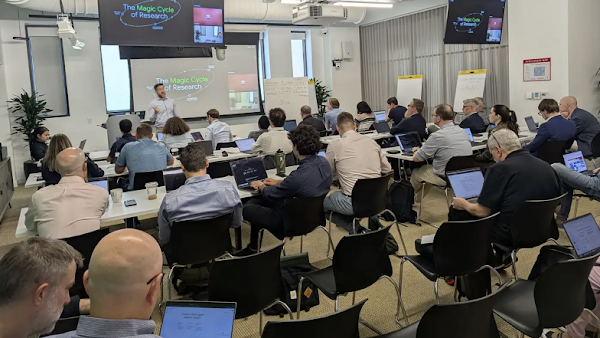professionally dressed people in an office working together with laptops