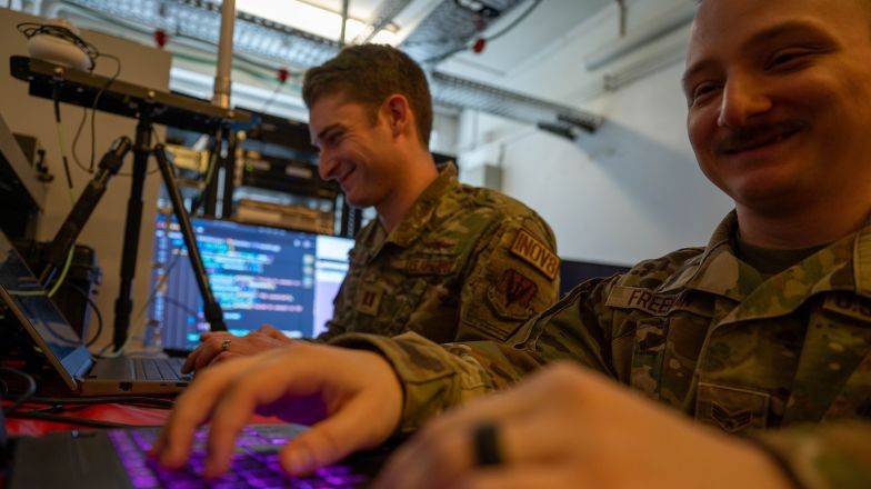 Two military members reviewing code on their devices