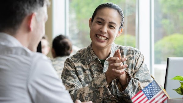 woman in military uniform smiling at man in button down